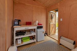AwanuiKaro Hut B - Ninety Mile Beachfront Cabin的小厨房配有炉灶和冰箱