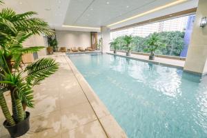 马尼拉Ardenhills Suites的棕榈树建筑中的一个大型游泳池
