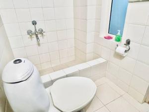 普塔帕蒂Shanthi Home Stay的白色的浴室设有卫生间和窗户。