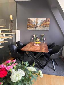 维也纳City-Penthouse mit 4 Terassen und Whirlpool的用餐室配有木桌和黑椅子