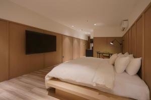 台南Hope Hotel Tainan的卧室配有白色的床和平面电视。