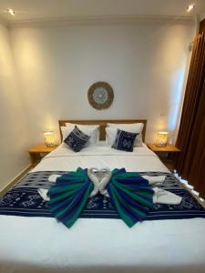 蓝梦岛The Pulau Bungalow的一间卧室配有一张蓝色和绿色的弓床