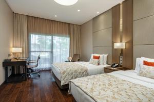 班加罗尔Palm Meadows Resort的酒店客房配有两张床和一张书桌
