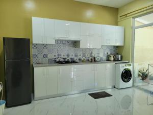 FeydhooLavender seenu feydhoo addu city的厨房配有白色橱柜和黑色冰箱。