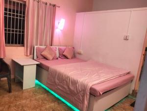 戈卡尔纳Greenland gokarna Ac and Non Ac的一间卧室配有一张粉红色的床,享有绿色的光线