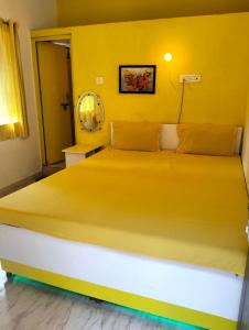 戈卡尔纳Greenland gokarna Ac and Non Ac的黄色墙的房间里一张床位