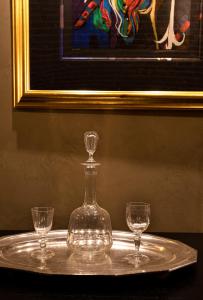 诺克斯维尔Hotel Cleo Knoxville的桌子上的玻璃瓶和两杯酒杯