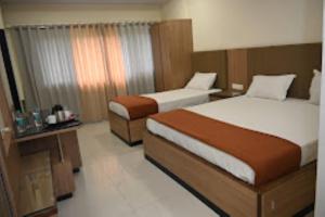 JālgaonHOTEL PRITAM PARK, Jalgaon, Maharashtra的一间酒店客房,房间内设有两张床