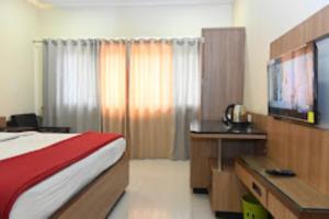JālgaonHOTEL PRITAM PARK, Jalgaon, Maharashtra的酒店客房配有一张床、一张书桌和一台电视。