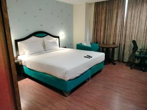 维沙卡帕特南HOTEL BLACK & WHITE的配有一张床和一把椅子的酒店客房