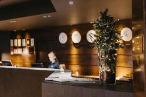 古多里古柯里马可波罗酒店的坐在餐厅柜台的一位妇女,餐厅里种着圣诞树