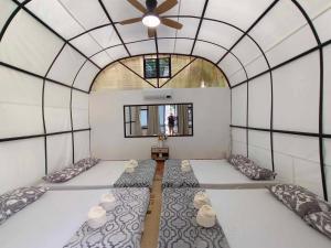 圣胡安Siquijor Glamping Village的一间设有三张床的客房,位于一个天花板的房间