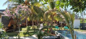 吉利阿尔班兰简易别墅的一个带棕榈树和椅子的花园以及一个游泳池