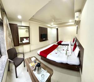 舍地Hotel Sai Chhatra的酒店客房配有一张床铺和一张桌子。