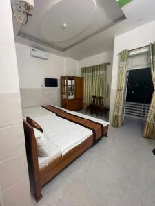 Phu YenHưng Phát Hotel的一间卧室配有一张床和一台电视。