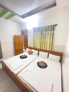 Phu YenHưng Phát Hotel的一间卧室配有两张带白色床单的床