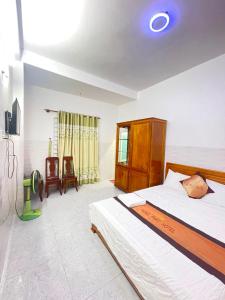 Phu YenHưng Phát Hotel的一间卧室配有一张床和一台电视