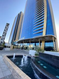 利雅德DAMAC Riyadh - Luxury Apartments的建筑物前方有喷泉的建筑物