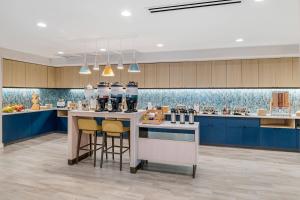 科洛尼尔海茨TownePlace Suites by Marriott Richmond Colonial Heights的厨房配有蓝色橱柜和带凳子的台面
