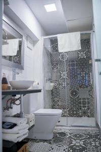 普拉森西亚Apartamentos Suites Cariátide的带淋浴、卫生间和盥洗盆的浴室
