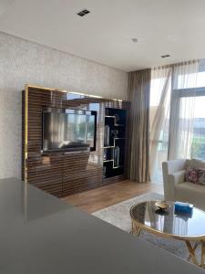 迪拜Modern 2BR and maid room with big terrace city walk的一间带电视和桌子的客厅