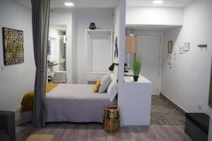 普拉森西亚Apartamentos Suites Cariátide的一间白色的卧室,配有床和客厅