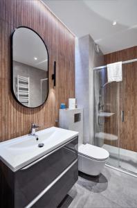 波兹南Żelazna Modern Studio的一间带水槽、卫生间和镜子的浴室