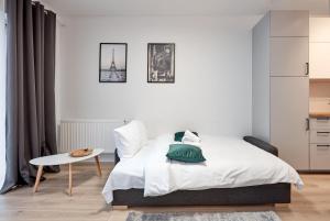 波兹南Żelazna Modern Studio的白色卧室配有床和桌子