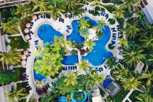 苏林海滩Holiday Inn Resort Phuket Surin Beach, an IHG Hotel的享有棕榈树度假村游泳池的空中景致