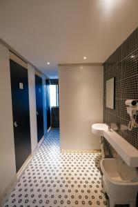 苏州不负韶华青年旅馆的一间带卫生间的浴室和瓷砖地板。