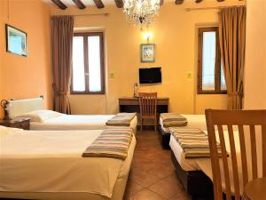 佛罗伦萨拉康缇希纳酒店的酒店客房设有三张床和一张书桌