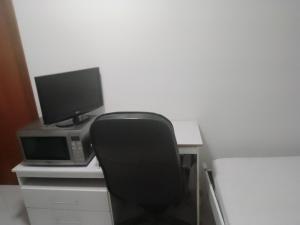 瓜鲁柳斯Studio Gru的一张桌子,配有电脑、显示器和椅子