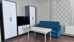 乌尔根奇Parvoz Hotel的客厅配有蓝色的沙发和电视