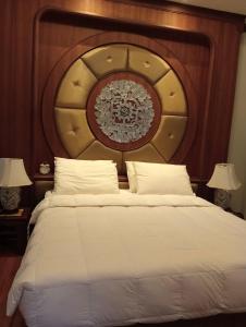 清迈Lunar Mansion Hotel的一间卧室配有一张大床和木制床头板