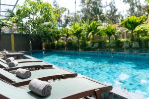 会安CHiEM HoiAn - The Beachside Boutique Hotel & Villa的游泳池里一排躺椅