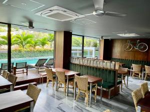 会安CHiEM HoiAn - The Beachside Boutique Hotel & Villa的一间带桌椅的餐厅和一个游泳池