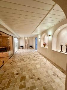 波亚纳布拉索夫罗马尼亚奥勒留伊姆帕拉图酒店的一条空的走廊,铺着瓷砖地板,设有天花板