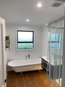 凯库拉Kereru Cottage的带窗户的浴室内的白色浴缸