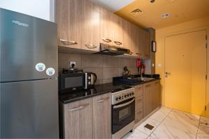 迪拜izzzilife Mint的厨房配有冰箱和微波炉。