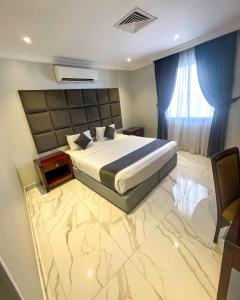科威特Continental Suite farwaniya的一间卧室配有一张特大号床和蓝色窗帘