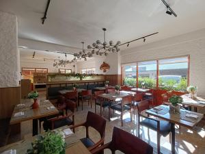 廷布Hotel Dralha的餐厅设有木桌、椅子和窗户。