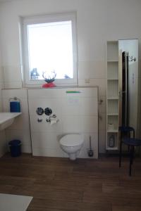 HofsgrundSport Rees- Ferienwohnung Ulrich的一间带白色卫生间的浴室和窗户。