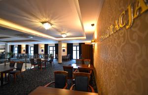 卢布林福克斯会议中心酒店的用餐室配有木桌和椅子