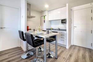 卡尔佩Apartamento Mirador - PlusHolidays的厨房配有桌子和黑色椅子