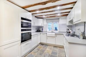 罗伯茨布里奇Perfectly Presented Cottage Pass the Keys的厨房配有白色橱柜和木制天花板