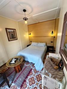 胡塞马Les IRIS的酒店客房配有一张床铺和一张桌子。