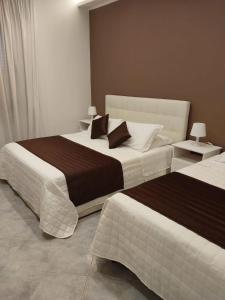 菲乌米奇诺monolocale speedy的一间卧室设有两张床和两张带台灯的桌子。