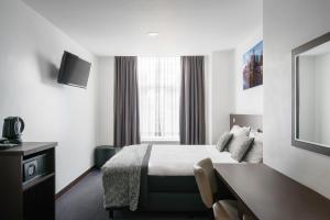阿姆斯特丹阿姆斯特丹城市花园酒店的配有一张床和一张书桌的酒店客房