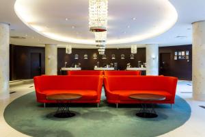 加里宁格勒加里宁格勒丽笙酒店的大堂设有红色椅子和桌子
