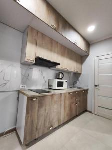 科克舍套Квартира посуточно的一间带木制橱柜和微波炉的厨房